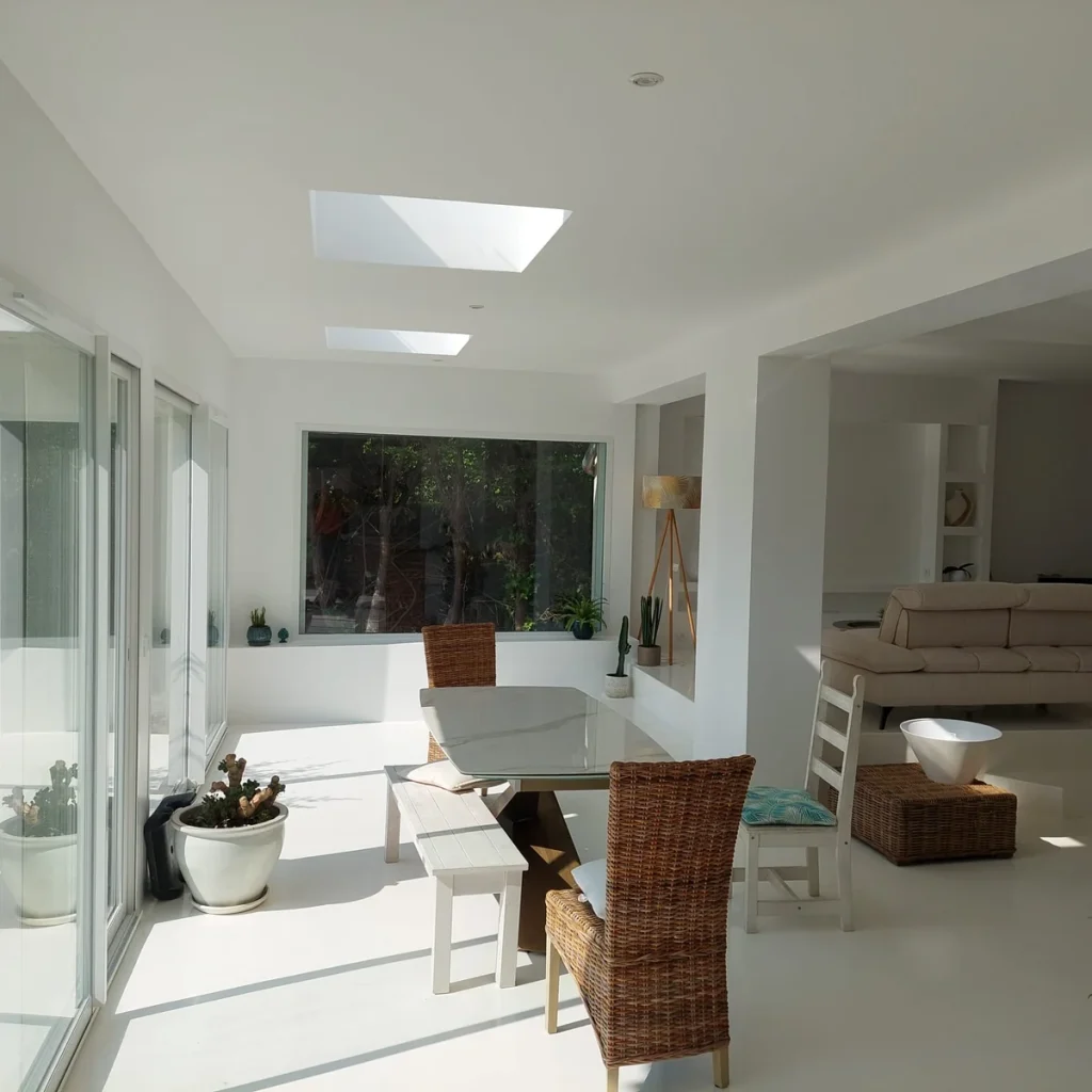 Séjour de l’extension terminé, puits de lumière en toiture et baies vitrées sur le jardin