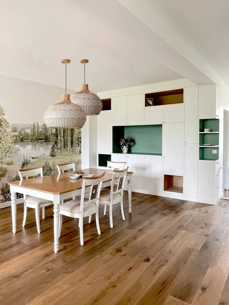 Salle à manger de Bruyères : rangements sur-mesure à niches colorées et papier peint panoramique