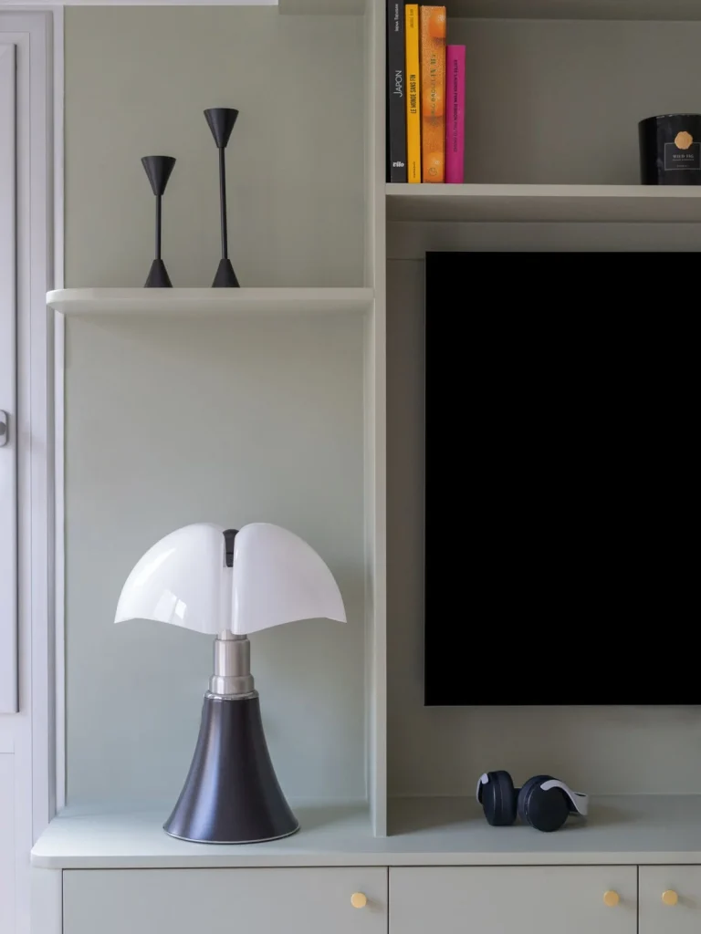Retour latéral du meuble sur-mesure, tablette et rangements bas à boutons laiton