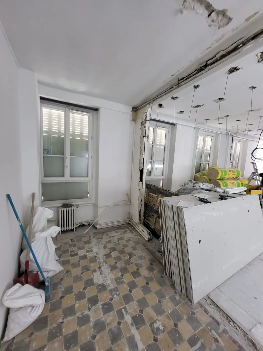 Le séjour de l’appartement Ganneron avant travaux, cloisons déposées et carrelage d’origine