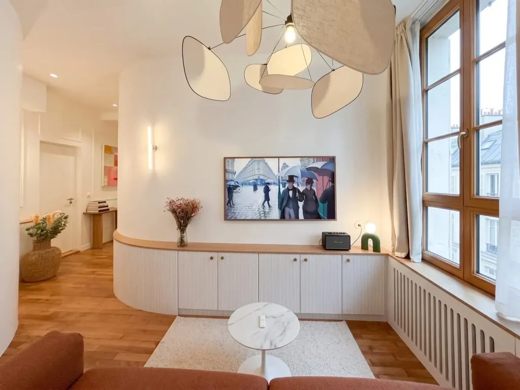 Meuble TV cannelé sur-mesure suivant la courbe du mur, séjour de l’appartement Ganneron