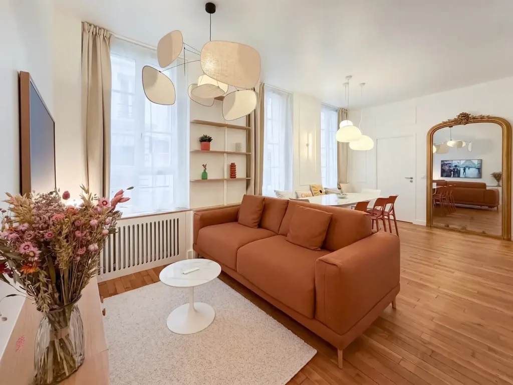 Séjour de l’appartement Ganneron après rénovation complète, bibliothèque sur-mesure et parquet