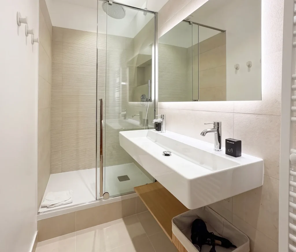 Salle de bain de l’appartement Lathuille avec douche à l’italienne et tablette en bois