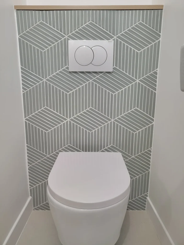 WC de l’appartement Lathuille, faïence verte à motif géométrique et couvre-joint en bois